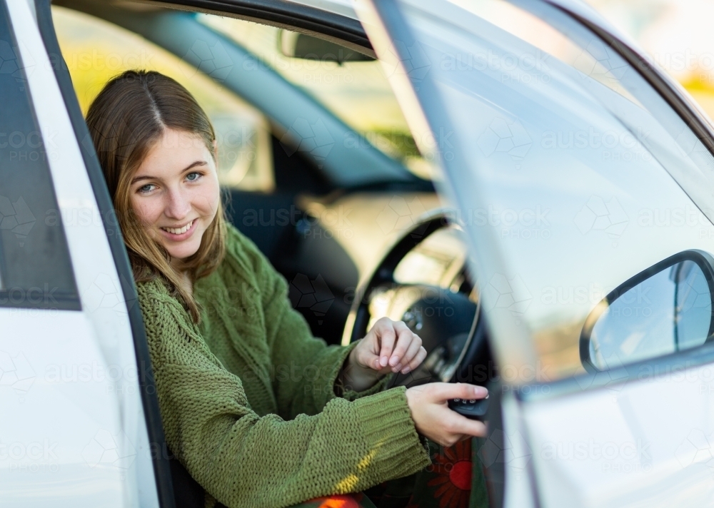 young woman in drivers seat of car with car key - Australian Stock Image