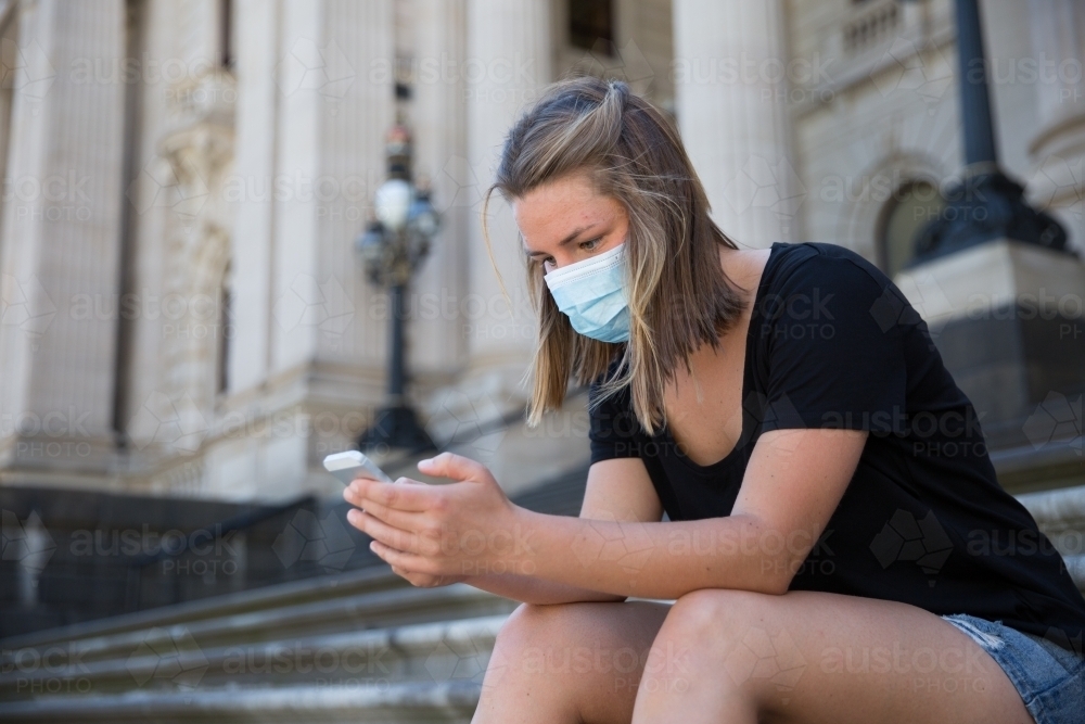 Young Woman in Face Mask on Parliament Steps - Australian Stock Image