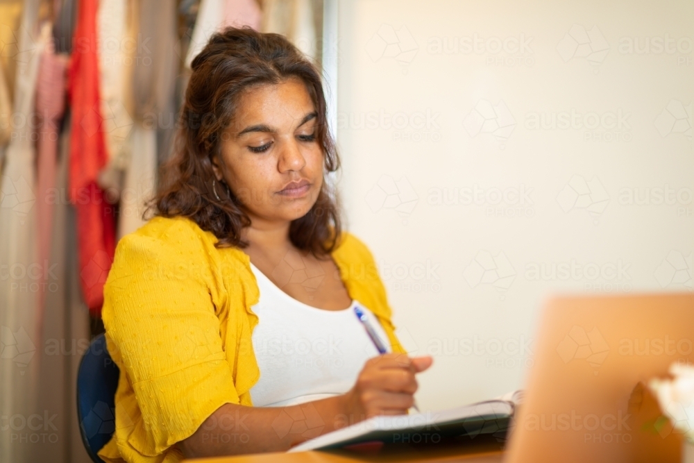 Young woman in home office doodling in home office - Australian Stock Image