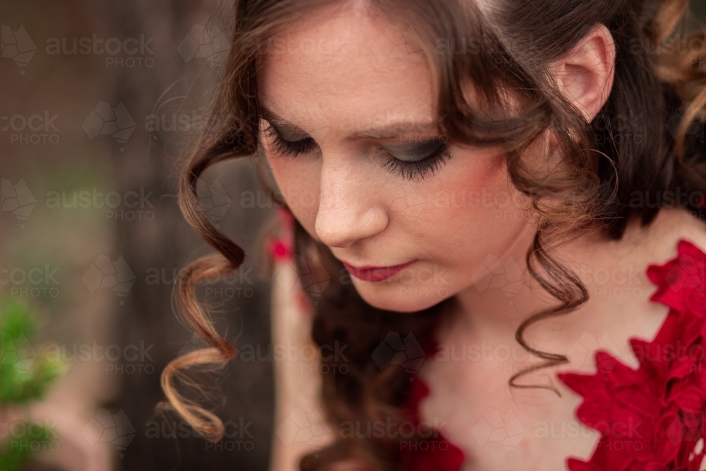 Image Of Young Woman In Red Dress Looking Down Hair And Makeup
