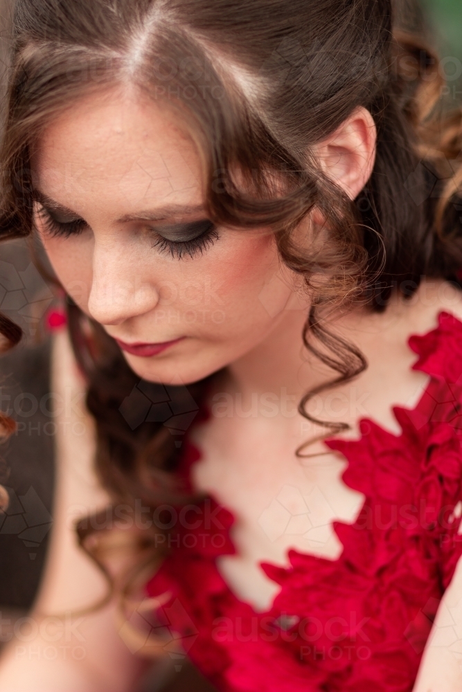 Image Of Young Woman In Red Dress Looking Down Hair And Makeup
