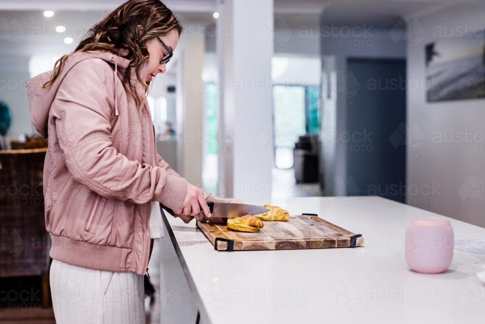 young woman in the kitchen, from a series featuring a woman with Down Syndrome - Australian Stock Image