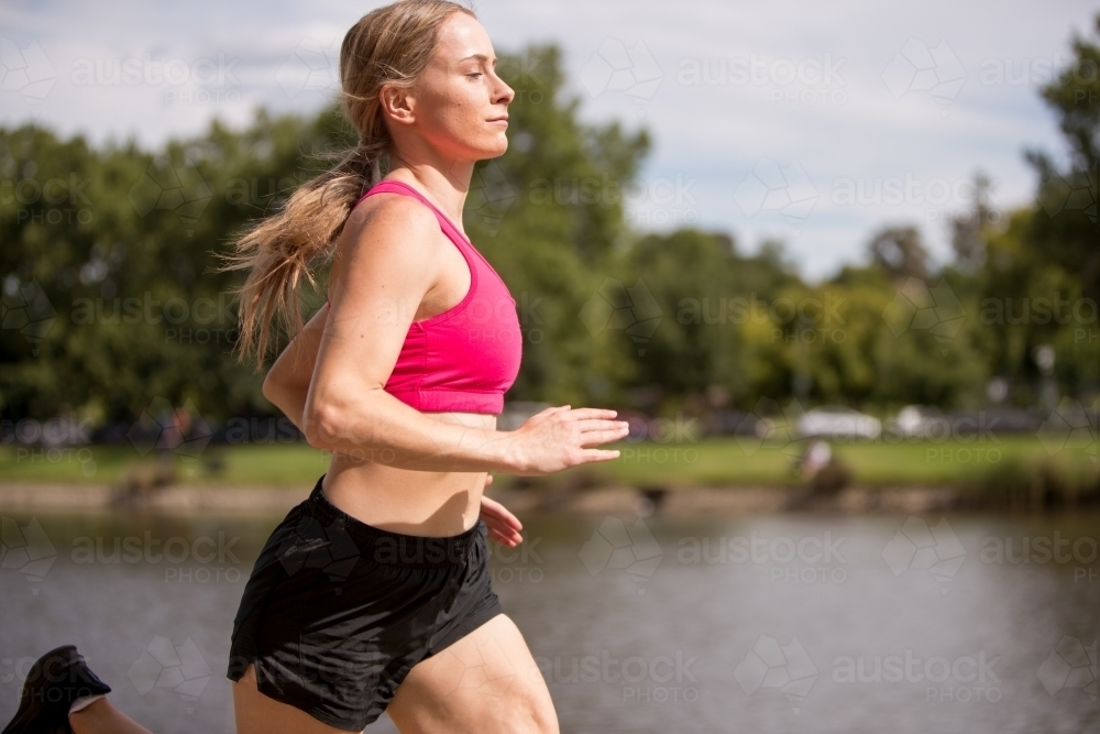 Young Woman Jogging by the River : Austockphoto Young Woman Jogging by the River - Australian Stock Image
