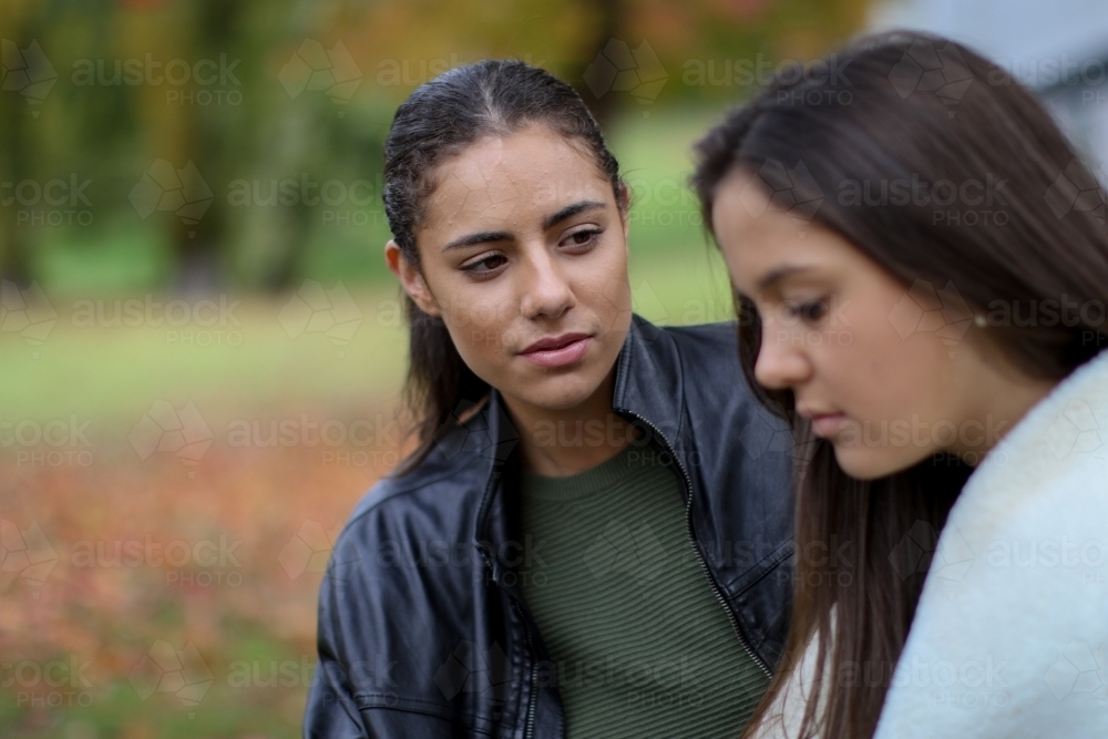 Young woman looking at female partner with concerned expression - Australian Stock Image