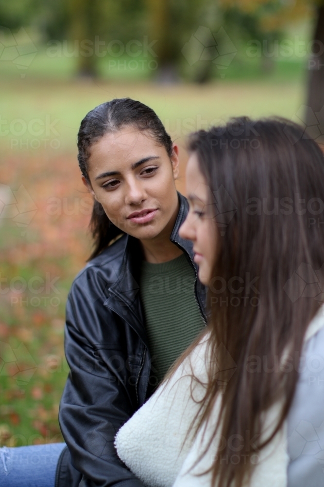 Young woman looking at female partner with loving expression - Australian Stock Image