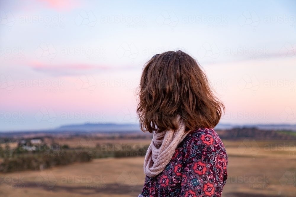 Young woman looking away at pastel sky view - Australian Stock Image