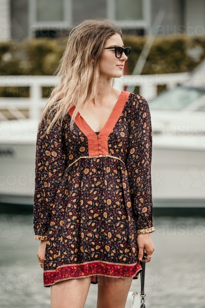 Young woman looking sideways wearing sunglasses. - Australian Stock Image