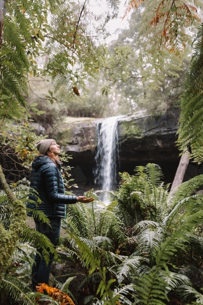 Young woman looking up towards the sky during a bushwalk - Australian Stock Image