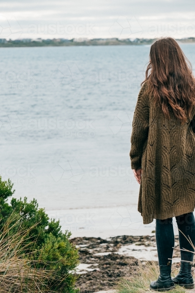 Young woman looks out to sea. - Australian Stock Image