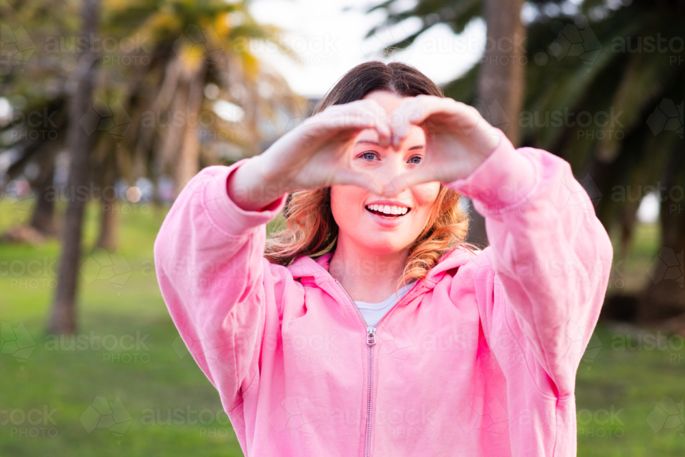 young woman making heart hands - Australian Stock Image