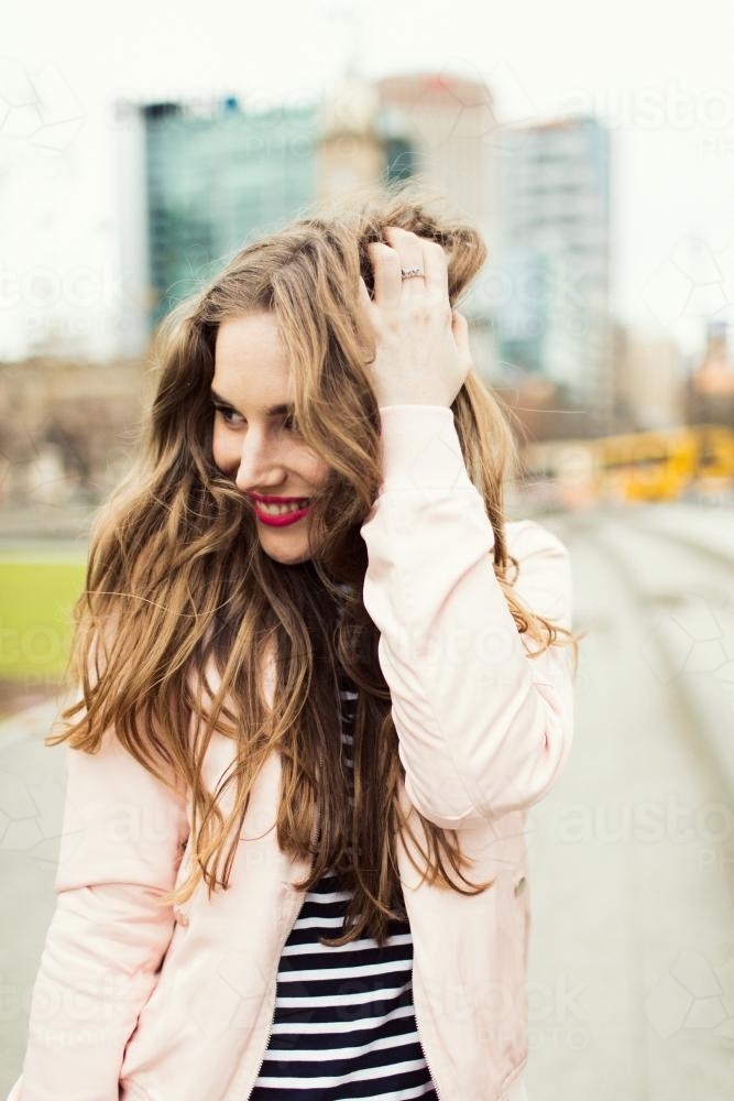 Young woman posing and smiling in the city - Australian Stock Image