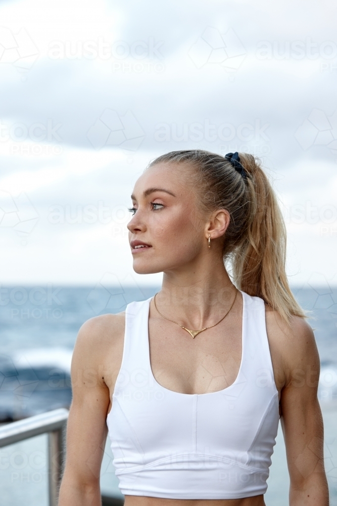 Young woman practising yoga by ocean - Australian Stock Image