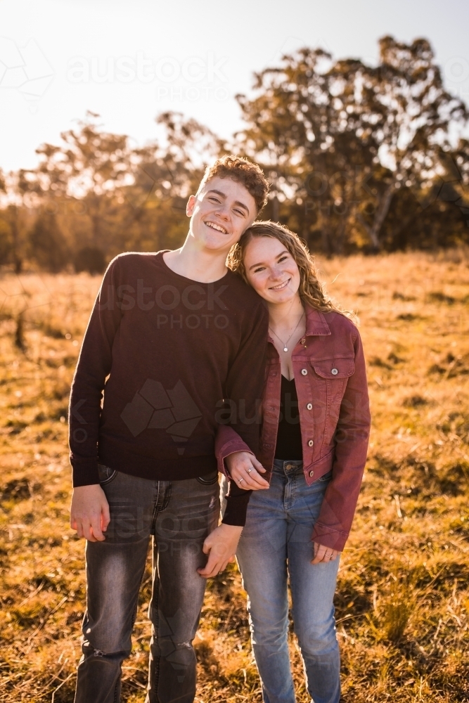 Young woman resting head on shoulder of young man happy smiling - Australian Stock Image