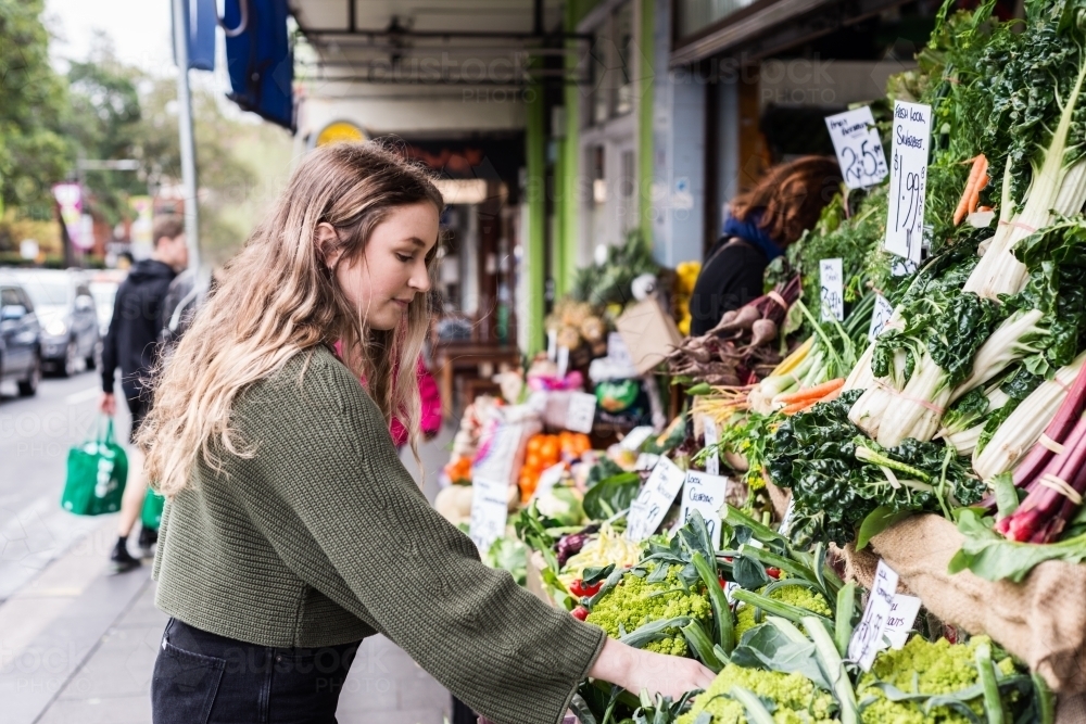 young woman shopping at greengrocer - Australian Stock Image