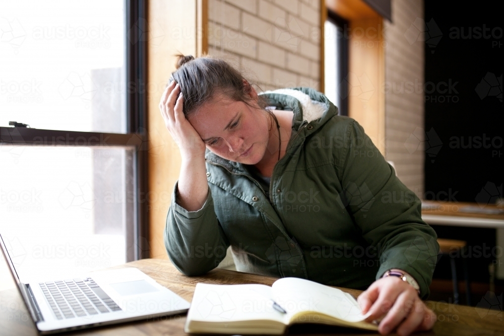 Young woman sitting at a desk in a classroom - Australian Stock Image