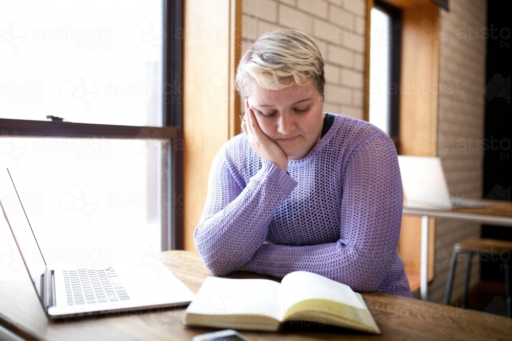 Young woman sitting at a desk in a classroom - Australian Stock Image