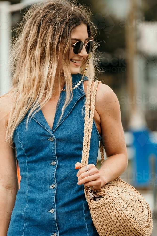 Young woman smiling and wearing sunglasses. - Australian Stock Image