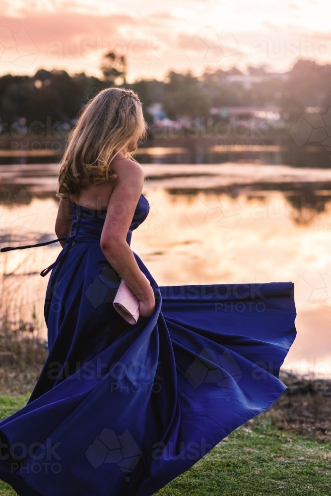 young woman spinning in formal dress in the afternoon light - Australian Stock Image