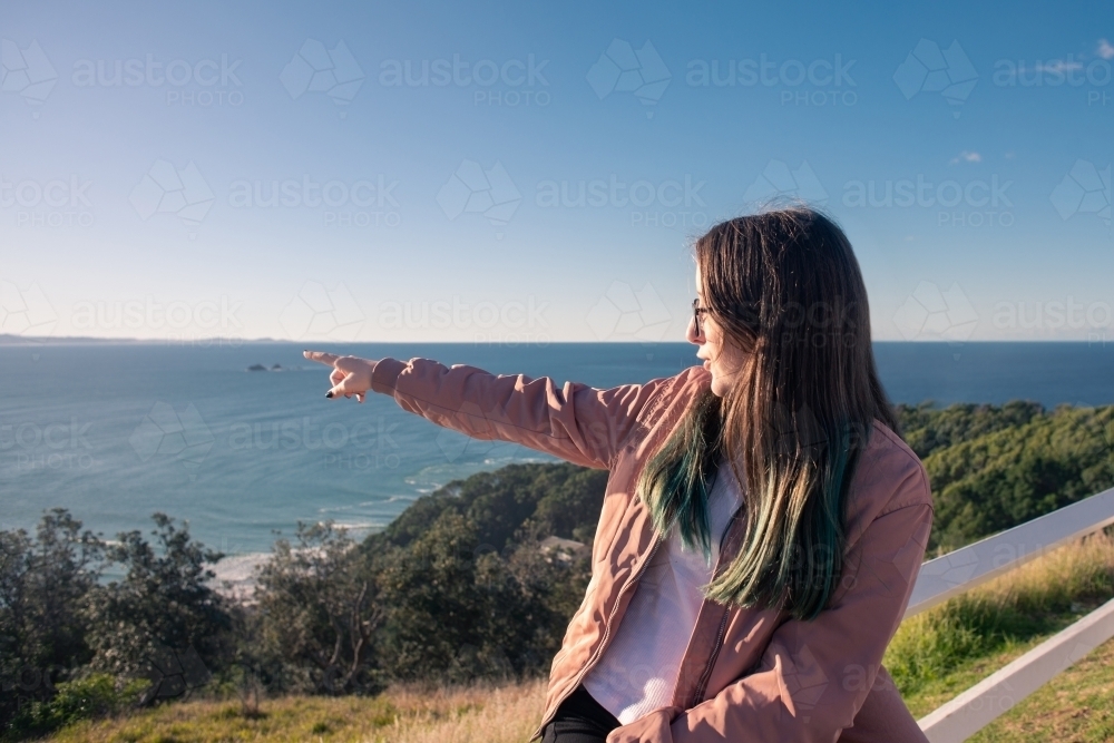 young woman spotting whales in the ocean - Australian Stock Image