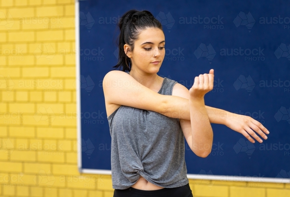 young woman stretching arms and shoulders - Australian Stock Image