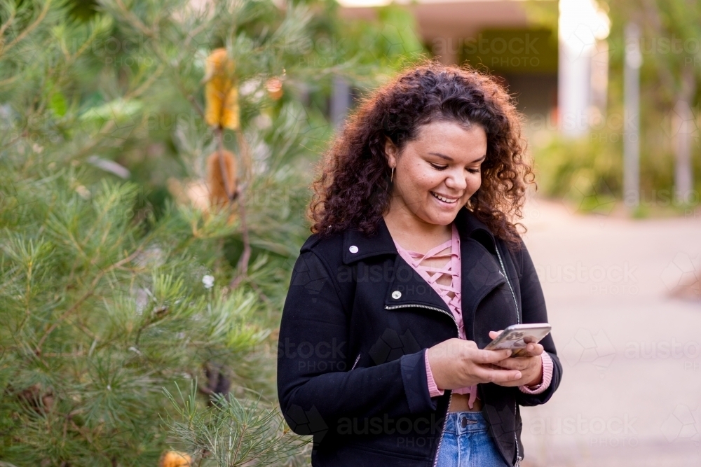 young woman using mobile phone - Australian Stock Image