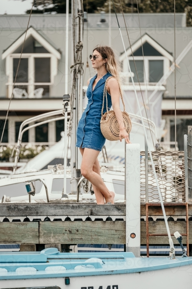 Young woman waiting at the boats on the jetty. - Australian Stock Image