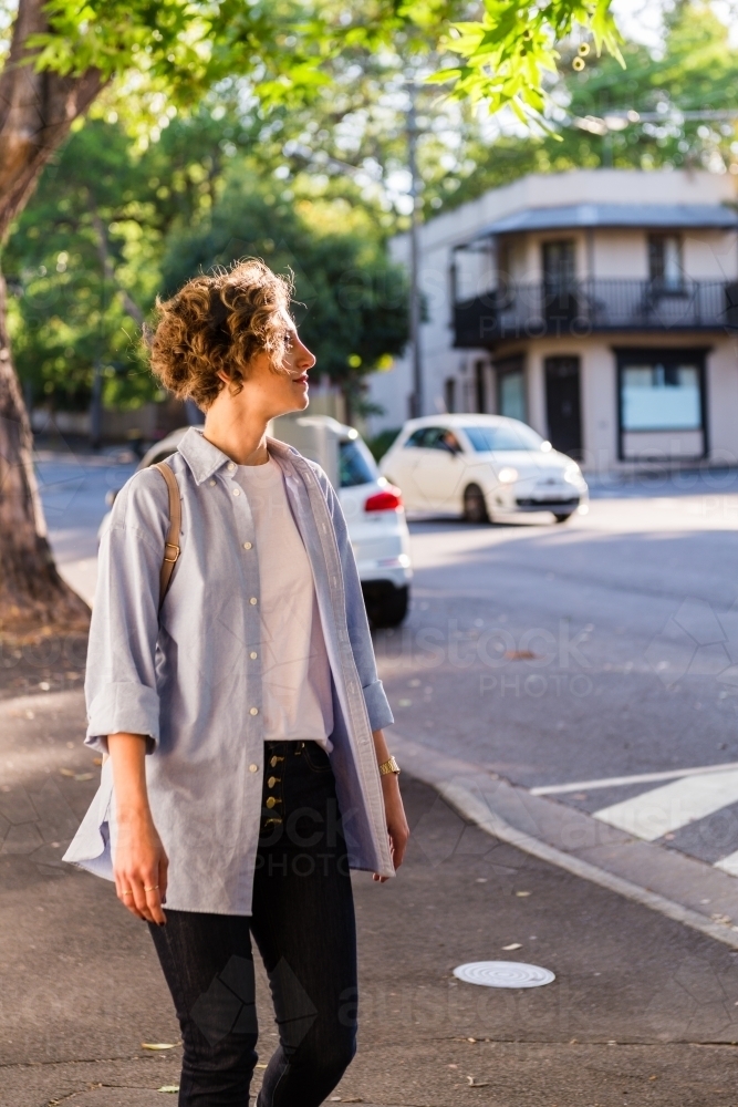 young woman walking  on the footpath in inner-city suburb - Australian Stock Image