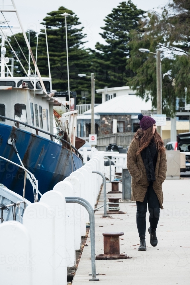 Young woman walks along the wharf in winter. - Australian Stock Image