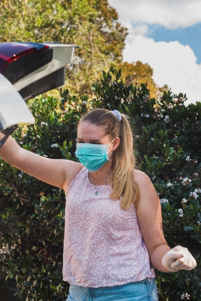 young woman wearing a face mask during covid19 outbreak - Australian Stock Image