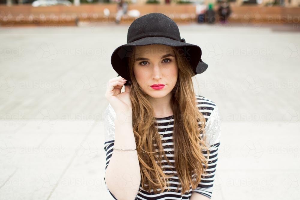 Young woman wearing a hat looking at camera - Australian Stock Image