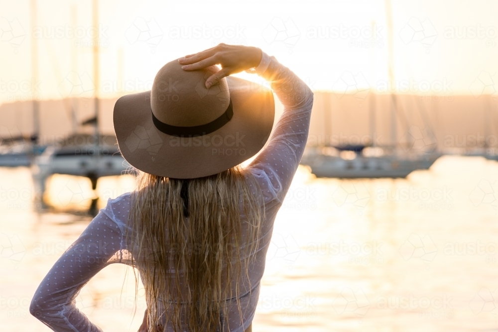 young woman wearing hat in afternoon light - Australian Stock Image