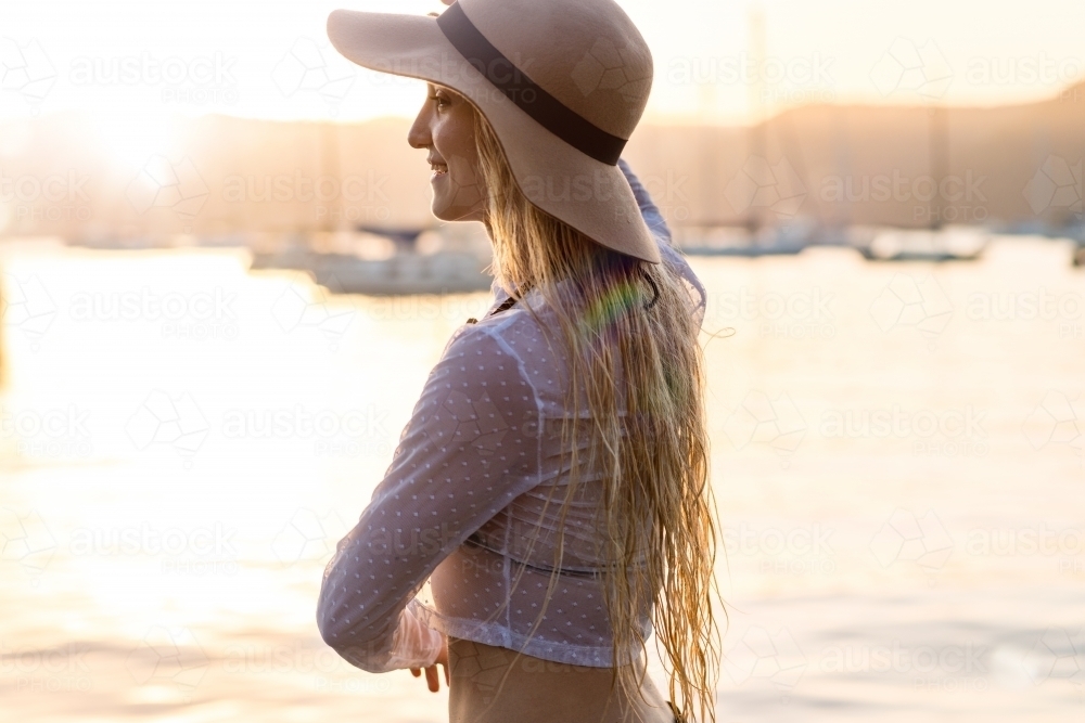 young woman wearing hat in afternoon light - Australian Stock Image