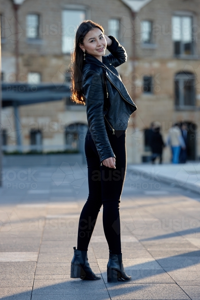 Young woman wearing leather jacket - Australian Stock Image