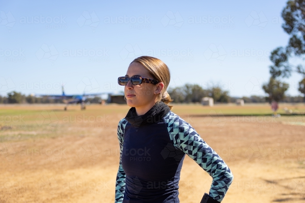 young woman wearing stylish sunglasses at country airstrip - Australian Stock Image