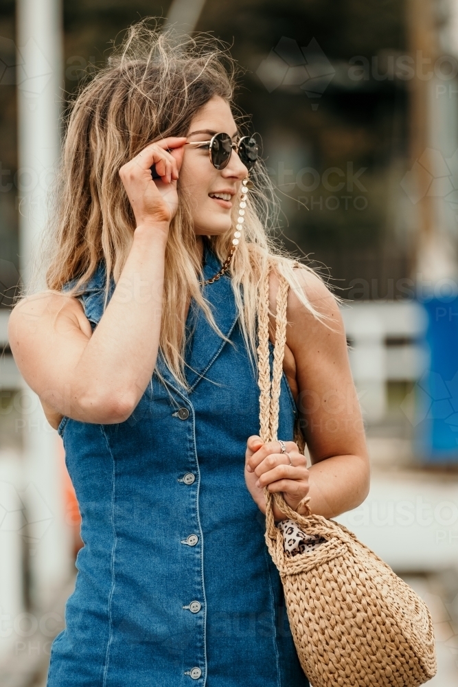 Young woman wears sunglasses - Australian Stock Image