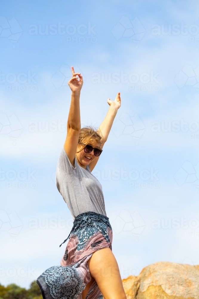 Young woman with arms in the air in exaultation - Australian Stock Image