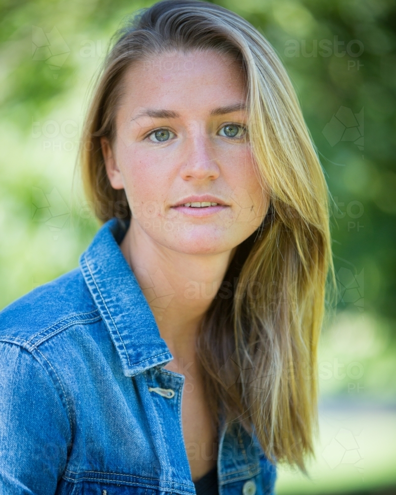 Young Woman with blonde hair wearing a blue denim jacket outdoors : Austockphoto Young Woman with blonde hair wearing a blue denim jacket outdoors - Australian Stock Image