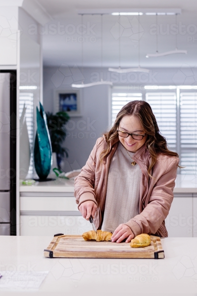 young woman with Down Syndrome, making breakfast - Australian Stock Image
