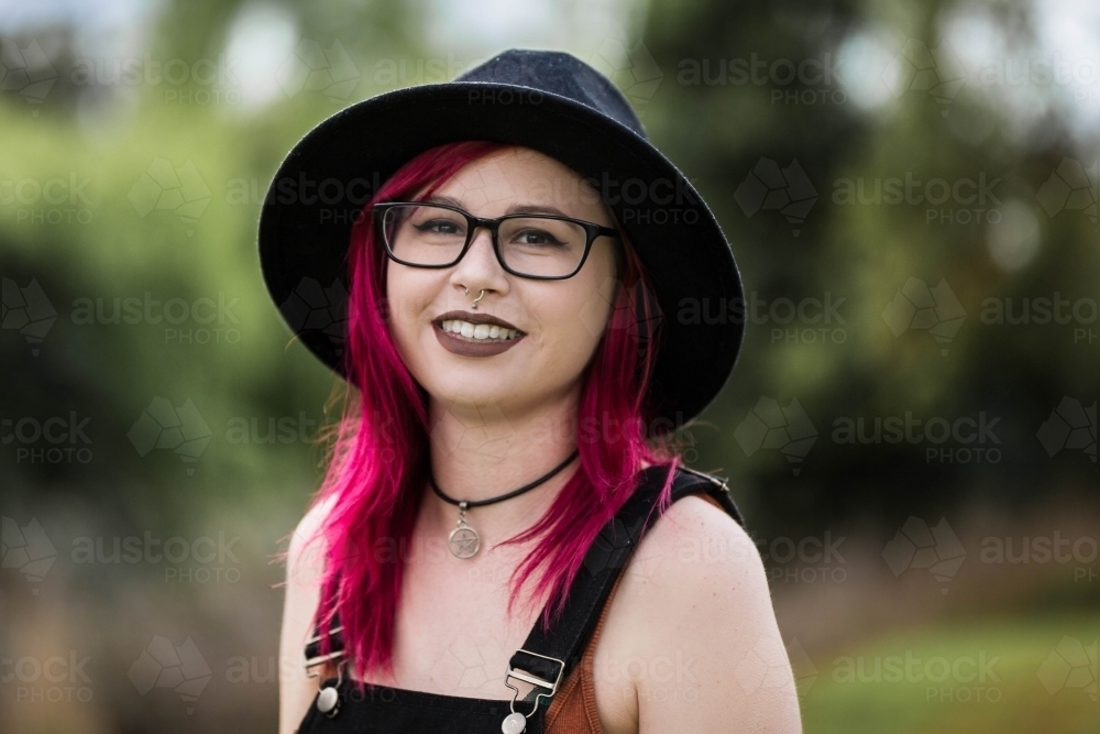 Young woman with nose piercing and red hair smiling - Australian Stock Image