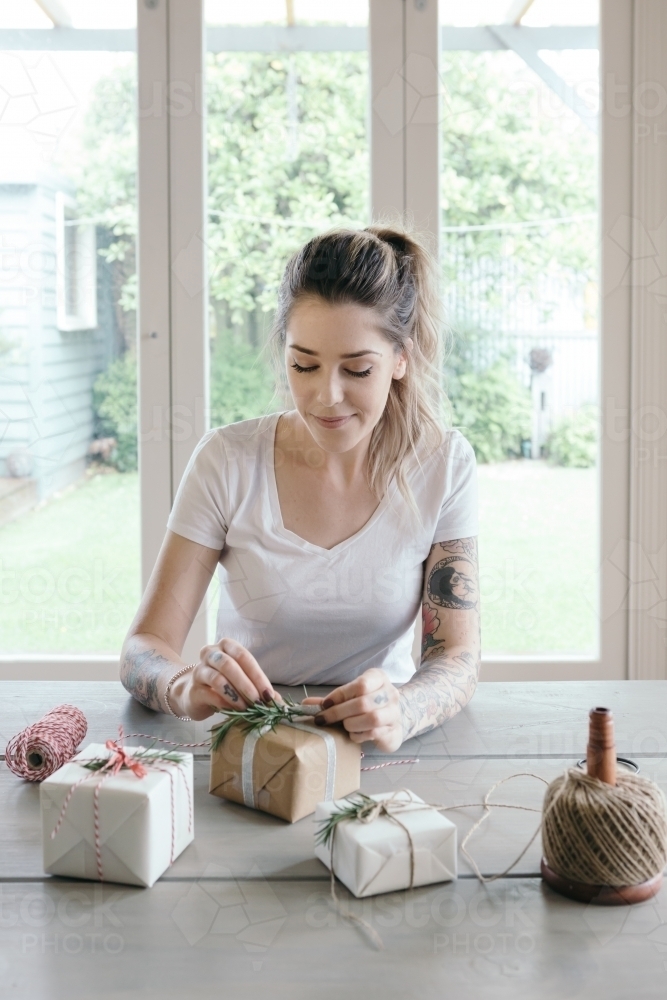 Young woman wrapping gifts in a Melbourne home - Australian Stock Image