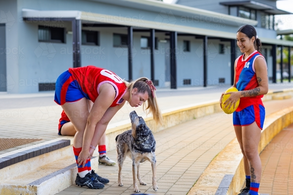 young women in sports uniforms and a dog - Australian Stock Image