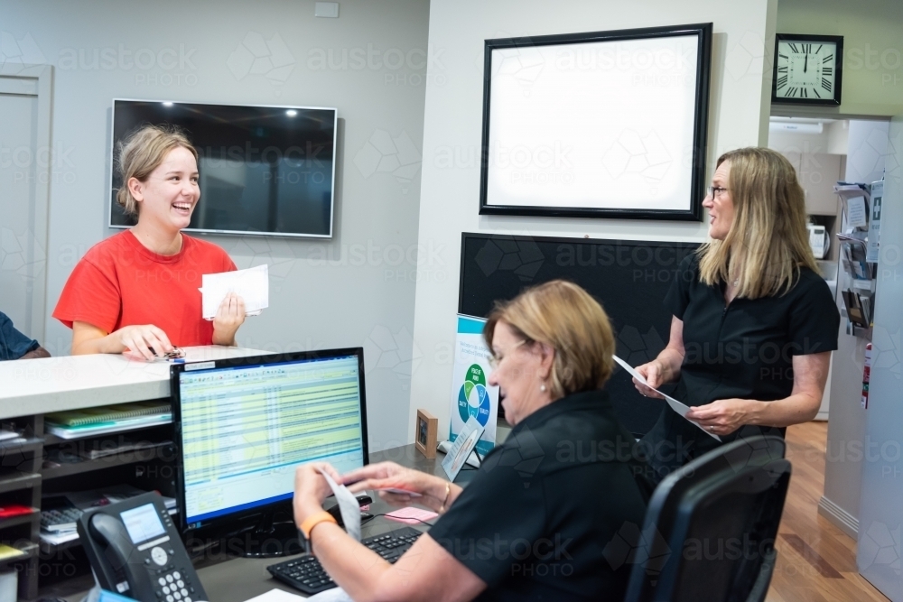 Young women talking in dental reception office - Australian Stock Image