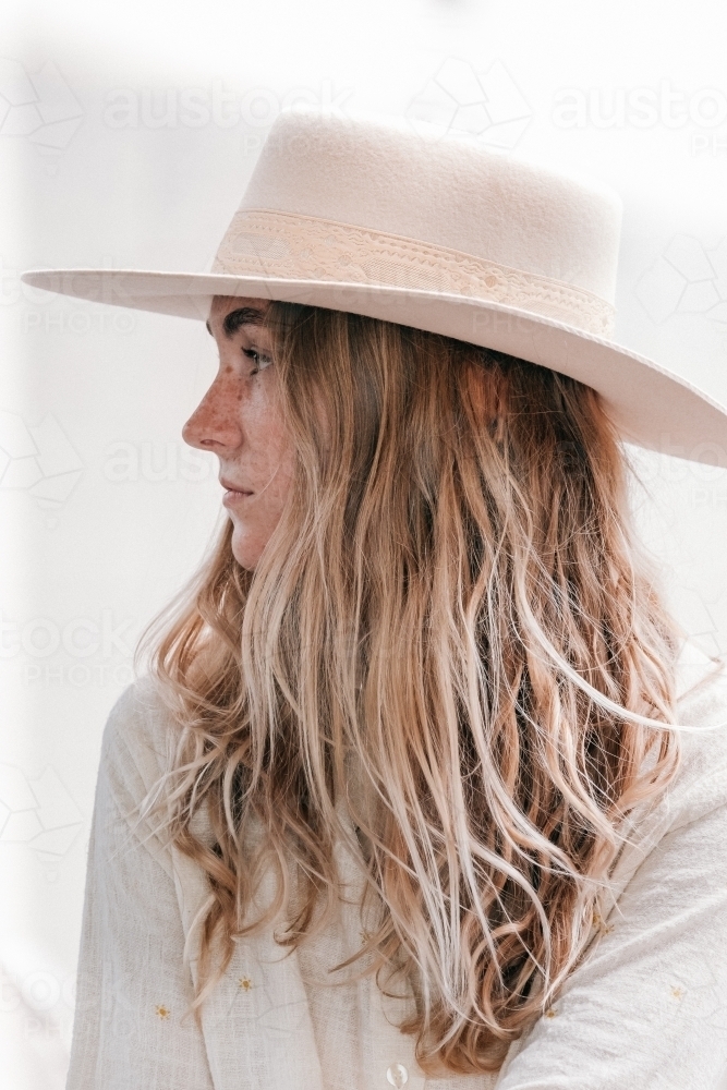 Young womens profile wearing a hat. - Australian Stock Image