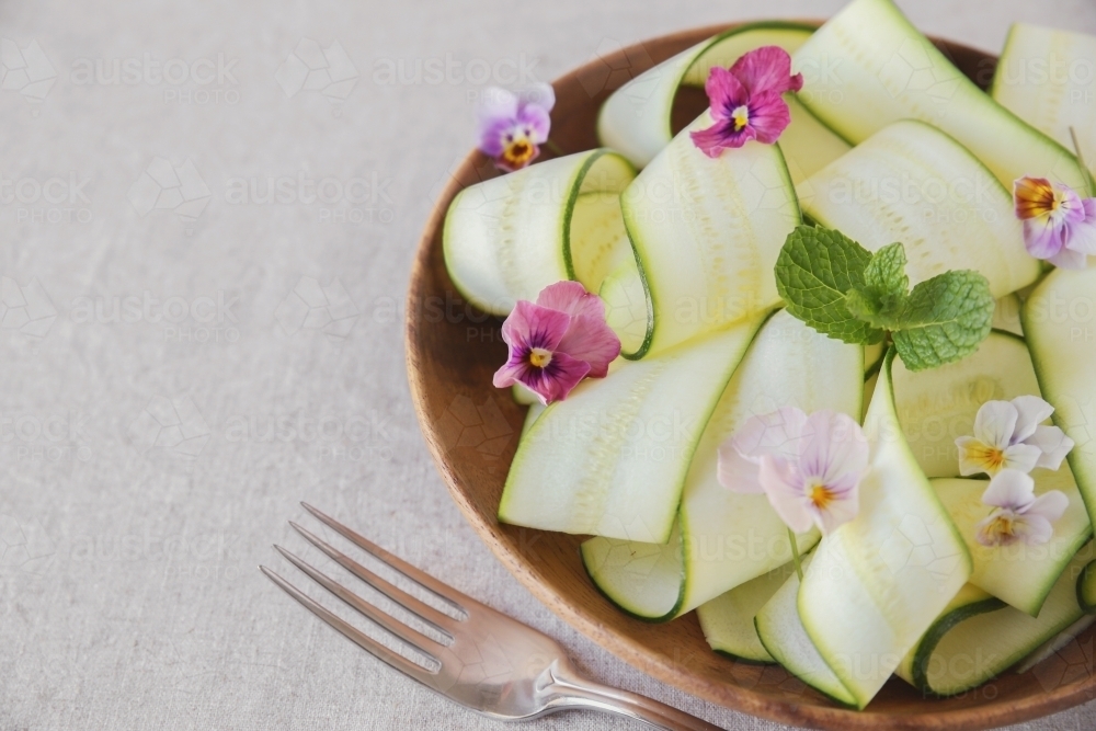 Zucchini salad with edible flowers, summer vegan salad - Australian Stock Image