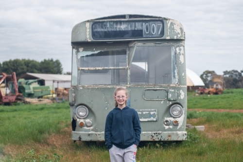 10 year old standing in front of old bus - Australian Stock Image