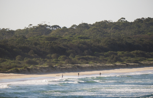 3 people beach fishing on a remote beach late afternoon light - Australian Stock Image