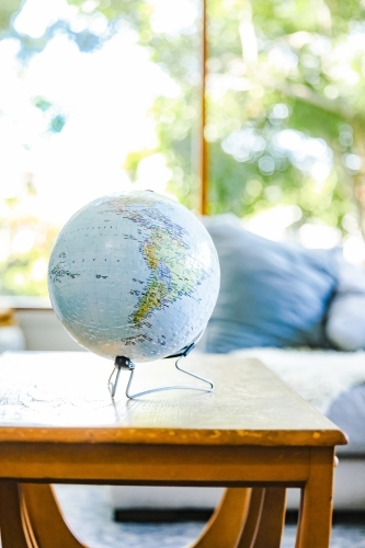 3D jigsaw puzzle of the Earth. Globe in well-lit living area on bright spring day. - Australian Stock Image