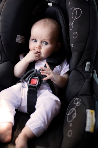 4 month old baby sitting in rear-facing car seat - Australian Stock Image