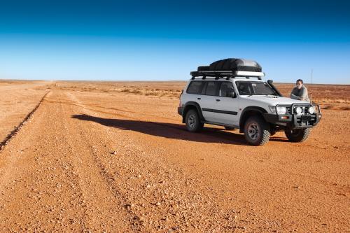 4 wheel drive vehicle alone on desert raod - Australian Stock Image
