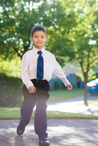 5 year old mixed race boy wearing his school uniform on his first day of school - Australian Stock Image